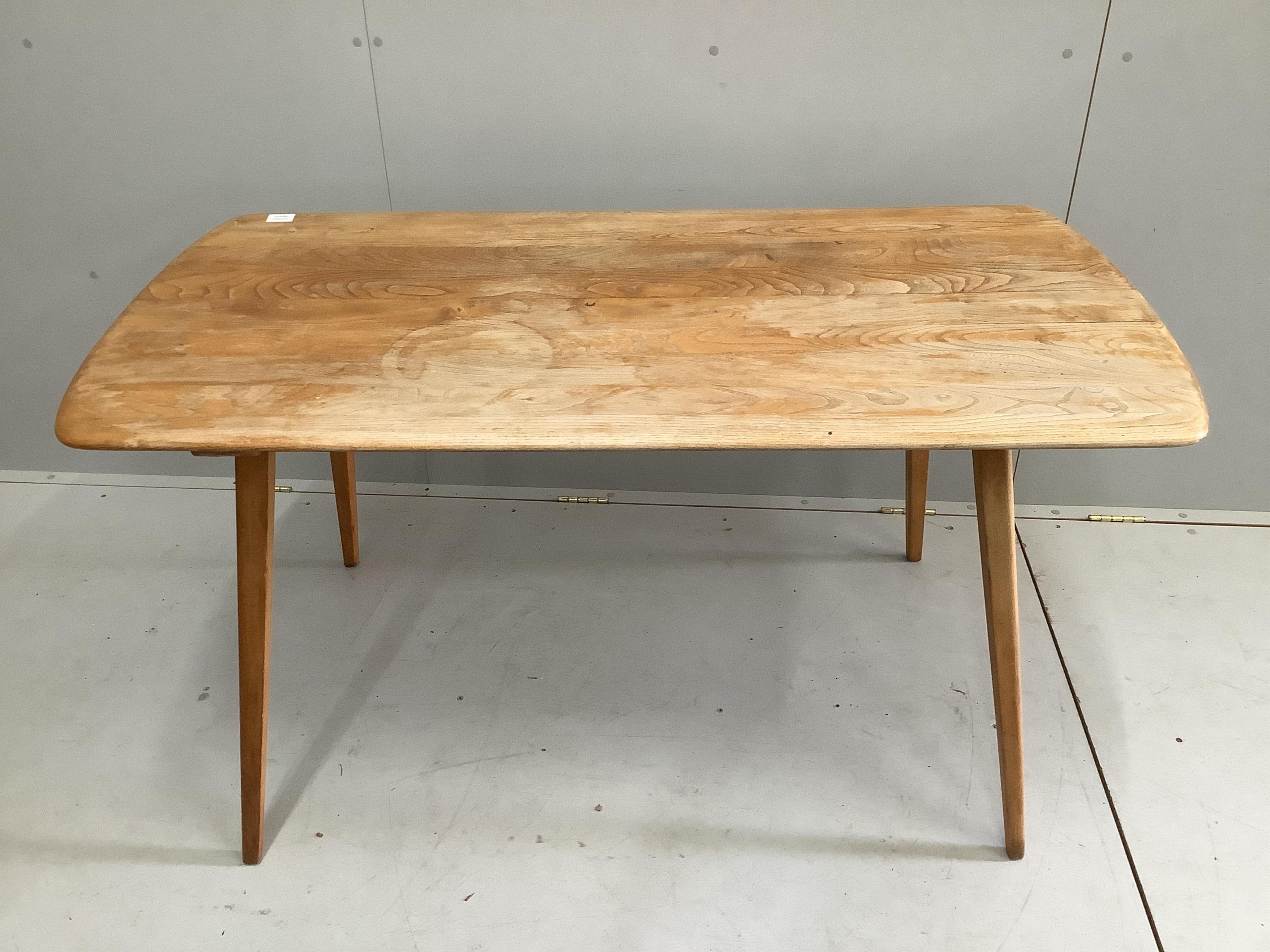 A mid century Ercol elm and beech rectangular dining table, width 135cm, depth 71cm, height 72cm. Condition - poor